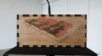Side profile of wooden laser-engraved enclosure of Sonic Mirror v2 hardware instrument.